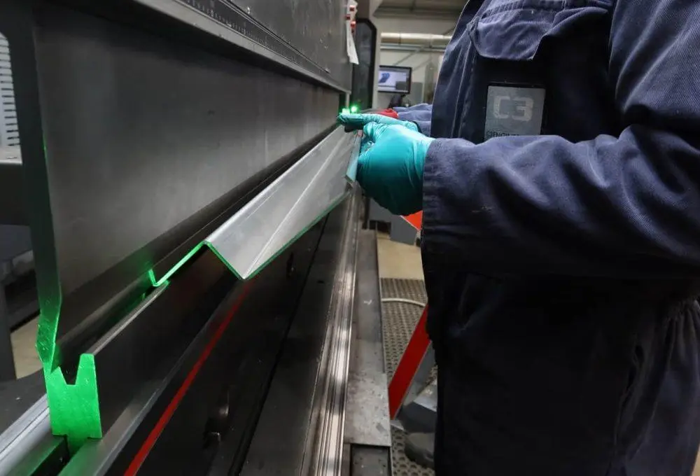 Engineer inspecting a CNC machined metal component using a press brake gauge